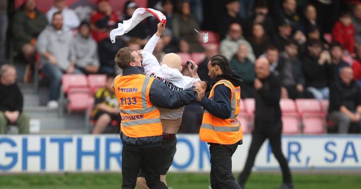 Pitch invaders take aim at Gary Neville as Salford City football match interrupted