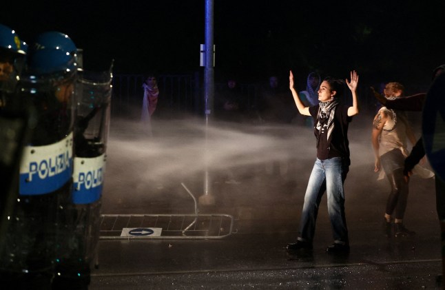 Police spray protesters with water canons during Italy