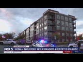 Woman in custody after standoff, reported stabbing