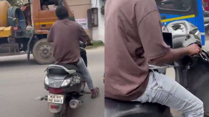 Man seen riding two-wheeler with phone in one hand, laptop on lap amidst heavy traffic, video sparks outrage
