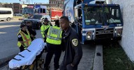 Garbage truck clips vehicle, crashes alongside building