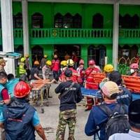 Survivor pulled from Indonesia school collapse as parents await news