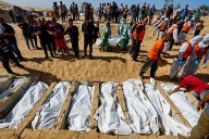 Mass funeral in Gaza as signs of alleged abuse reported on bodies returned by Israel