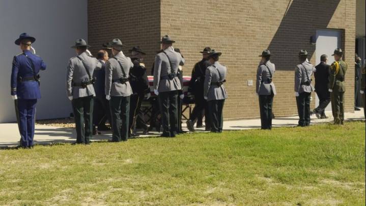 Law enforcement officers and community members pay respects during viewing hours for fallen deputy