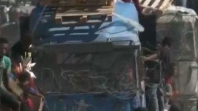 Palestinians rush to grab aid from trucks moving through Gaza