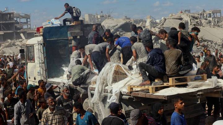Los palestinos recogen la ayuda de los camiones que circulan por Gaza