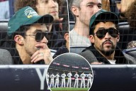 Bad Bunny sits during God Bless America at Yankee Stadium during MLB Playoff game