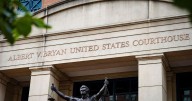 Fired federal prosecutor tapes a note about duty to the door on his way out