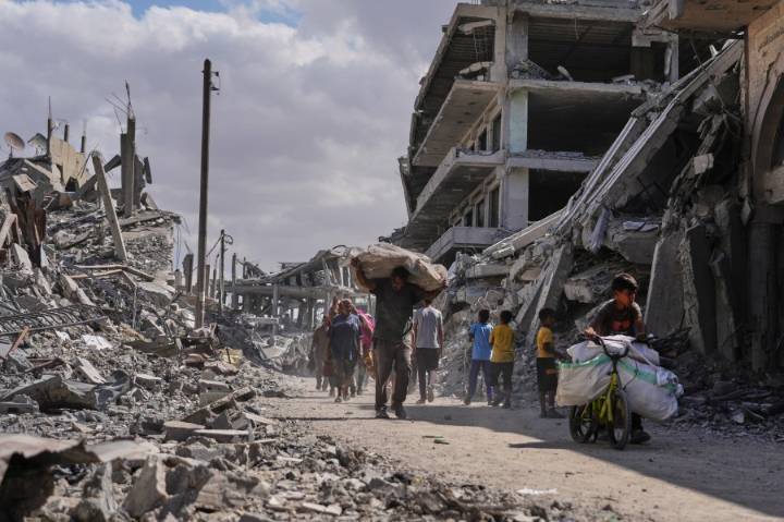 Thousands of Palestinians return to what remains of their homes as Gaza ceasefire takes effect