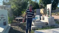 Padre limpia tumba de su hijo previo a Día de Muertos