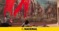 Dos activistas rocían con pintura un cuadro de Cristóbal Colón en el Día de la Hispanidad