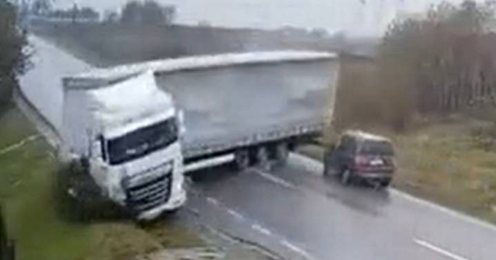 Moment jackknifed lorry crushes car killing two after losing control on slippery road