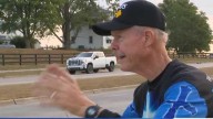 Kent Proudfit waves at Urbandale motorists to brighten their days