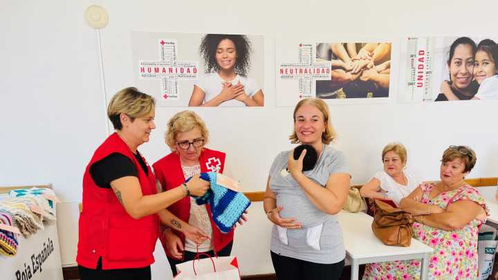 Mujeres mayores elaboran mantitas solidarias para bebés del programa de acogimiento familiar de Cruz Roja en Almería