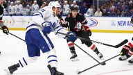 Maple Leafs and Sabres players sport Blue Jays jerseys during walk