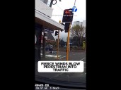 Fierce winds blow pedestrian into traffic