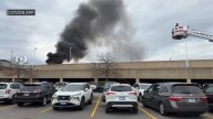 Plume of smoke billows from fire in parking lot at Woodfield Mall