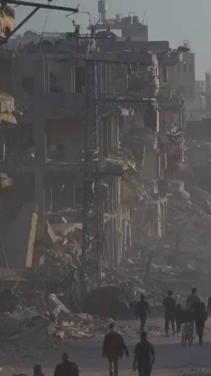 Displaced Palestinians pass scenes of devastation in Gaza City as they return to their homes