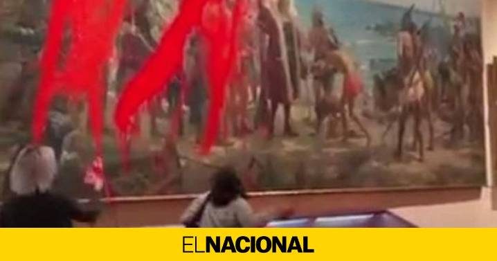 Dos activistas rocían con pintura un cuadro de Cristóbal Colón en el Día de la Hispanidad
