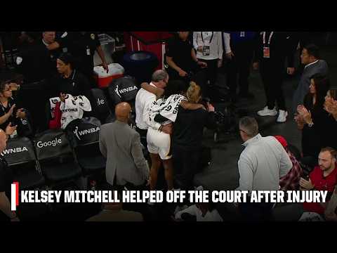 Kelsey Mitchell is helped off the court after appearing to sustain a leg injury