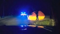 After a police pursuit of a huge inflatable pumpkin, body cam video shows officer struggling with it