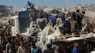 Los palestinos recogen la ayuda de los camiones que circulan por Gaza