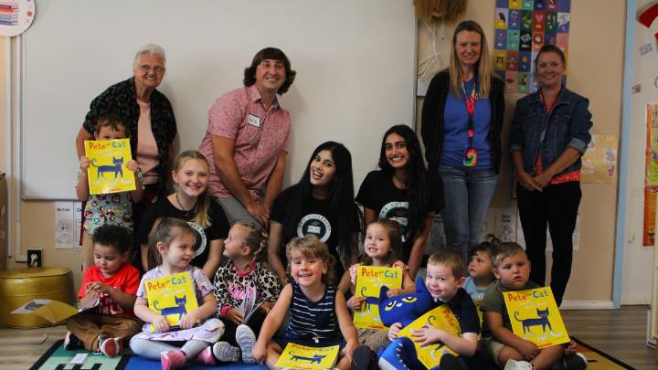Volunteers foster literacy by reading to children and giving them books