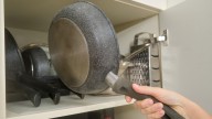Declutter All The Pot Lids In Your Cabinets With One Simple Stick