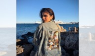 After director Maruthi, actress Malavika Mohanan now sports outfit bearing 'The Raja Saab' poster in Greece
