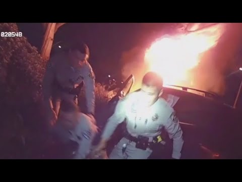 Officers rush in to save man in burning car