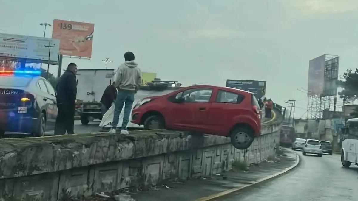 Choque en Paseo Tollocan deja un vehículo colgando del puente