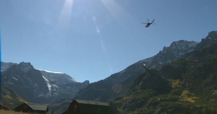 Helicopter crew maneuvers replacement bridge into canyon near Rimrock Lake